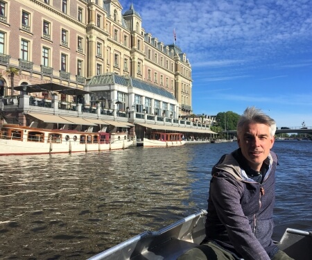 Mann in einem Boot vor dem Amstel Hotel in Amsterdam