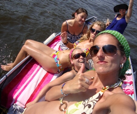 Frauen sonnen sich und segeln auf einem Boot Frauen sonnen sich und segeln auf einem Boot